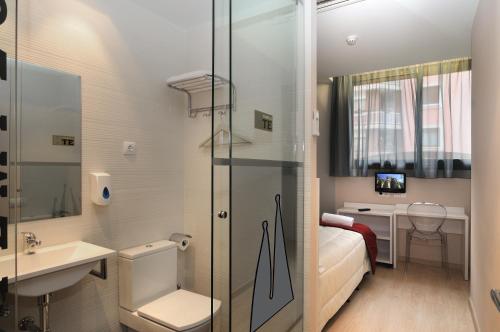 a small bathroom with a bed and a sink at Hostemplo Sagrada Familia in Barcelona