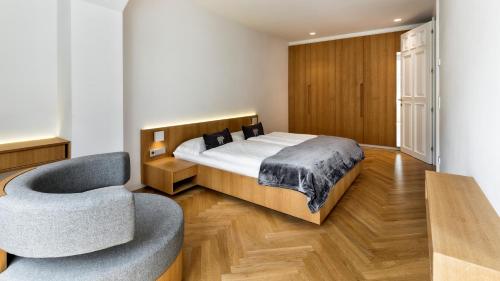 1 dormitorio con 1 cama y 1 silla en Apartment Genziana, en Ortisei