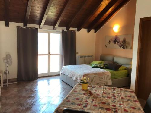 a bedroom with a bed and a table and a window at New Attic Lake View 4 in Varenna