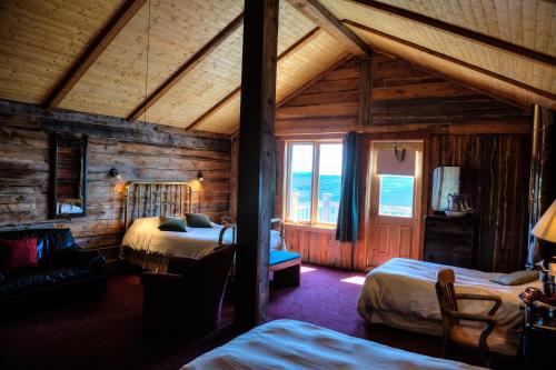 a bedroom with two beds in a wooden cabin at Auberge Cap au Leste in Sainte-Rose-du-Nord