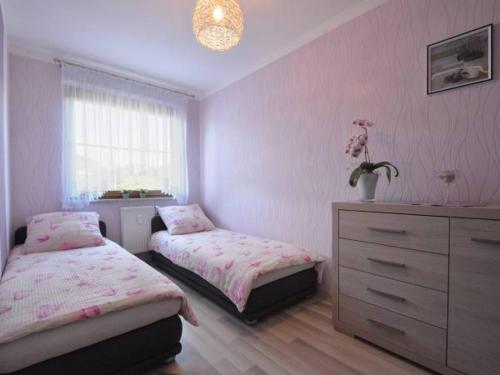 sypialnia z 2 łóżkami, komodą i oknem w obiekcie Apartament na Jagiellońskiej w Kołobrzegu