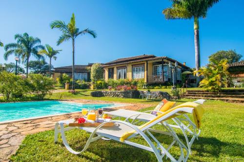 a table and chairs next to a swimming pool at Pousada Paço do Lavradio in São João del Rei