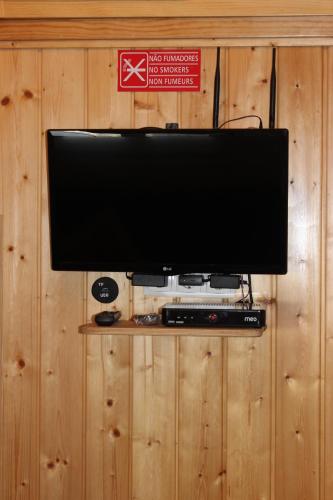 a flat screen tv hanging on a wooden wall at Nest Apartment in Zambujeira do Mar