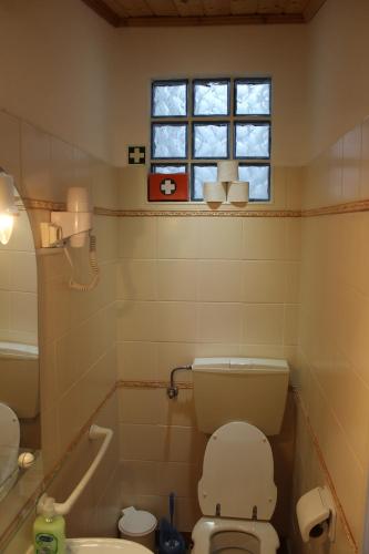 a bathroom with a toilet and a window at Nest Apartment in Zambujeira do Mar