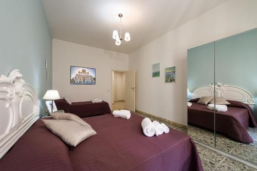 a bedroom with two beds and a mirror at House Bonifacio in Rome