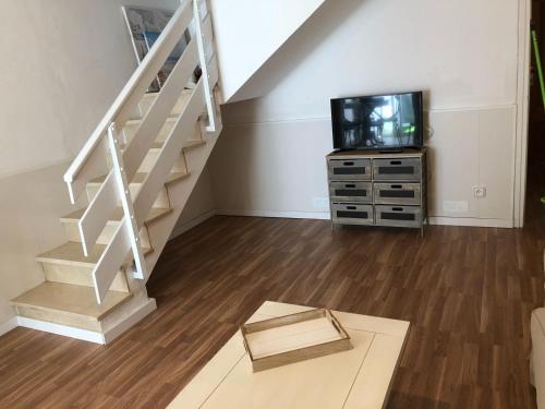 a living room with a staircase and a tv at Vilasardemarlux2 in Vilassar de Mar