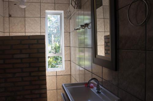 baño con lavabo y ventana en Morada d'Omar 4 Ilhas, en Bombinhas
