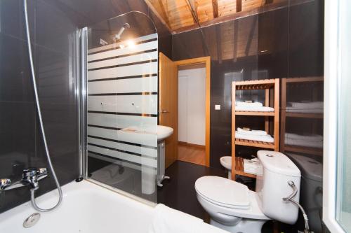 y baño con ducha, aseo y lavamanos. en La Casa del Conde de Gelves Apartments, en Sevilla