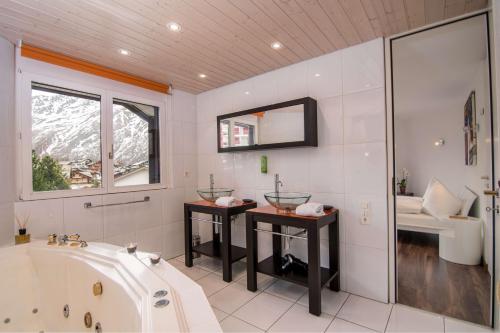 uma grande casa de banho com banheira e lavatório em Haus Allegra em Saas-Fee