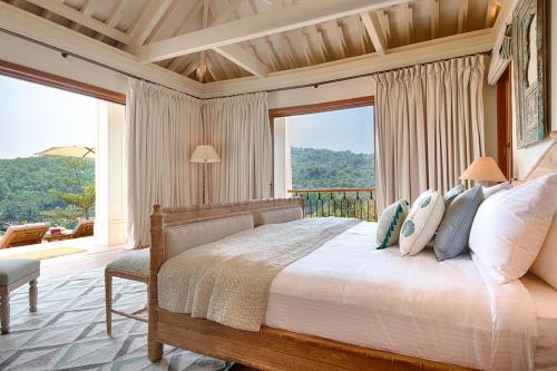 a bedroom with a bed and a large window at Kahani Paradise in Gokarna