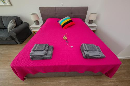 une table rose avec une couverture rose sur elle dans l'établissement Villa Bramasole Lun, à Novalja