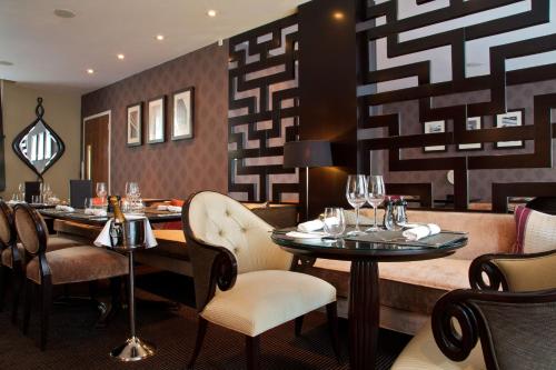 a restaurant with tables and chairs with wine glasses at Ten Manchester Street Hotel in London