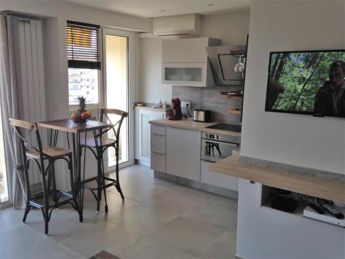 een keuken met een tafel en stoelen in een kamer bij Le Cros de Cagnes in Cagnes-sur-Mer