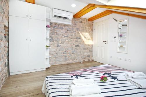 - une chambre avec un lit et un mur en briques dans l'établissement Seafront Apartment 2, à Cavtat