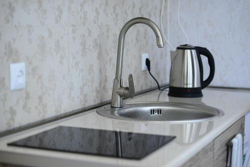 a kitchen counter with a sink with a tea kettle at Ana's Apartment in Old Tbilisi in Tbilisi City