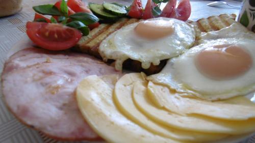 a plate of food with eggs and bread and tomatoes at Staś -przy szkole nr 3 w Skawie in Skawa
