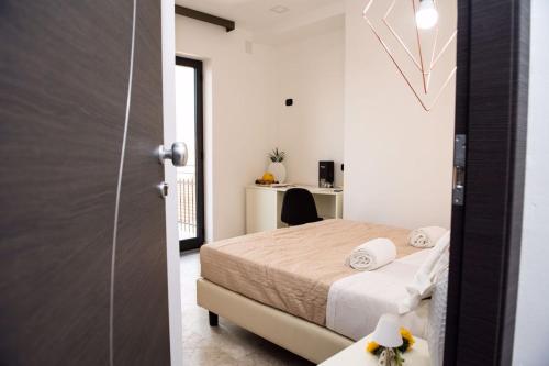 1 dormitorio con 1 cama y puerta de cristal en Albergo Milazzo Inn AiMori en Milazzo