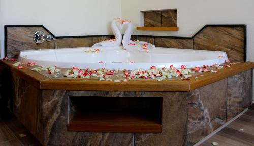 two flamingos are sitting in a bathtub covered in flowers at Hotel & Balneario Los Angeles in Taxco de Alarcón