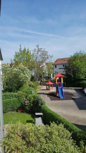 a playground with a blue slide and a red roof at Loft Orchidee in Überlingen