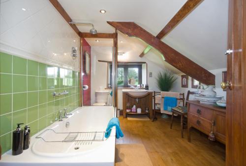 baño grande con bañera y lavamanos en Tregondale Manor Farm, en Liskeard