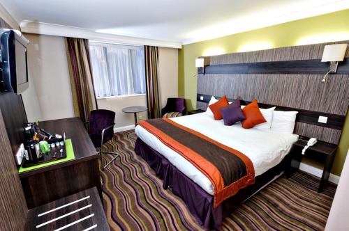 a hotel room with a bed and a television at Link Hotel in Loughborough