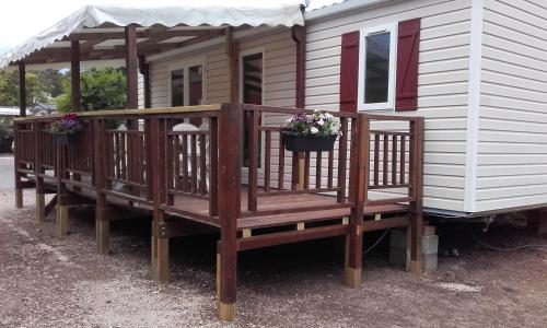 Una casa con una terraza con flores. en Spacieux Mobil-Home Fréjus en Fréjus