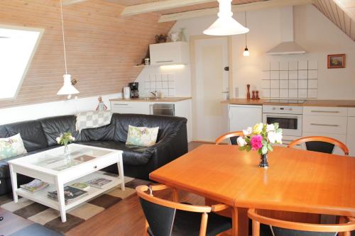 a kitchen and living room with a table and chairs at Tvillinggaard Thy in Vang