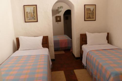 a room with two beds in a room at Hotel Mision Santa Barbara RNT 4799 in Barichara