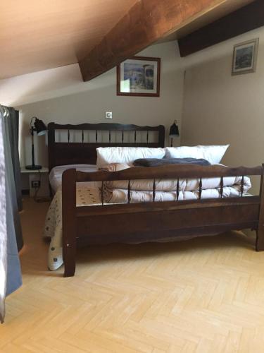 une chambre avec un grand lit en bois dans une pièce dans l'établissement Mazet Lavande, à Saint-Martin-de-Brômes