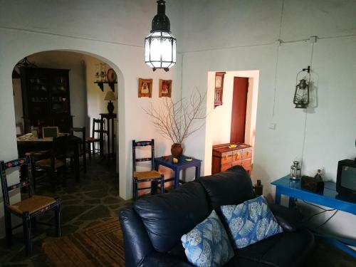 a living room with a black leather couch and a table at Monte dos Velhos in Reguengos de Monsaraz