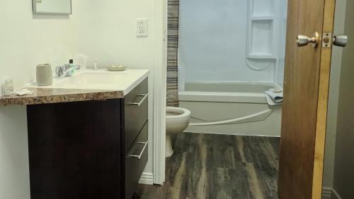 a bathroom with a sink and a toilet and a tub at Auberge motel drakkar in Shawinigan