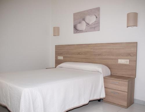 a bedroom with two beds and a wooden headboard at Hotel Punta Seame in Portonovo