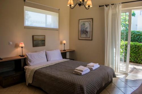 a bedroom with a bed with two towels on it at Anavyssos Cottage in Palaiá Fókaia