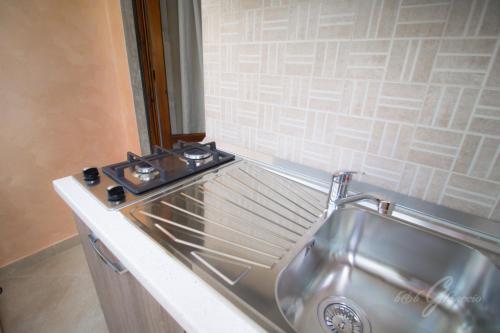 a kitchen with a stove and a stainless steel sink at B&B Ghiaccio in Gallipoli