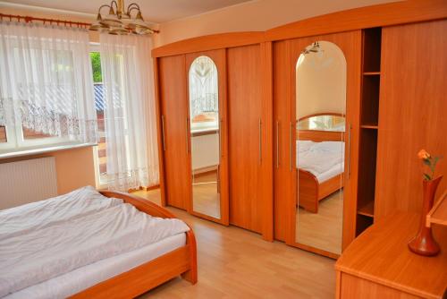 1 dormitorio con cama y espejo en Pokoje Marco, en Władysławowo