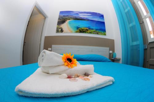 a bed with a towel with a flower on it at I Paesaggi in Castellammare del Golfo
