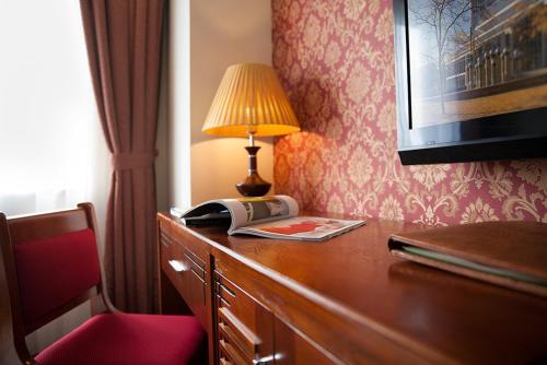 a hotel room with a desk with a lamp and a telephone at First Eden Hotel - Hang Bun in Hanoi