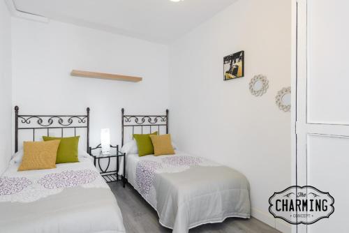 マドリードにあるCharming Argensola Centerの白い壁の客室内のベッド2台