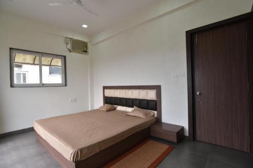 a bedroom with a bed and a window and a door at Modern Villa One in Lonavala