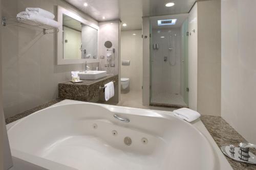 a bathroom with a large white tub and a sink at Grand Sirenis Riviera Maya Resort & Spa All Inclusive in Akumal