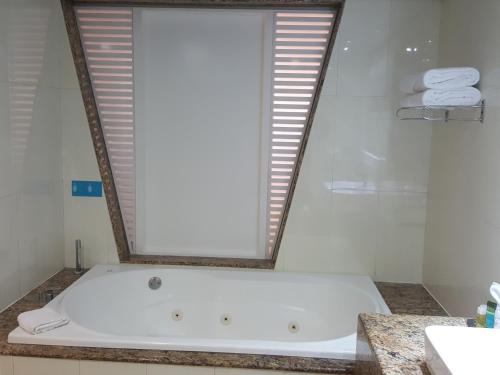 a bath tub in a bathroom with a mirror at Grand Sirenis Riviera Maya Resort & Spa All Inclusive in Akumal