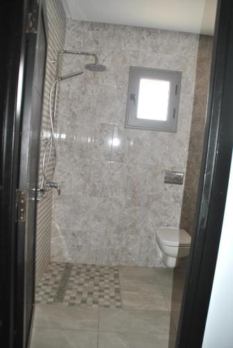 a bathroom with a shower and a toilet at Residence La Perle in Triffa