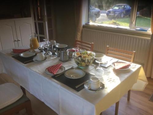 a table with a white table cloth and a bowl of food at Hillview House in Cootehill