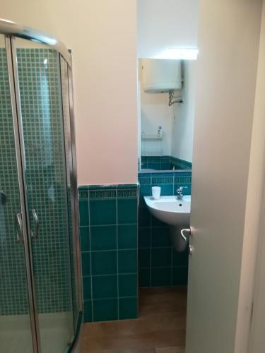 a bathroom with green tiled walls and a sink at Casetta Mare in Castiglione della Pescaia