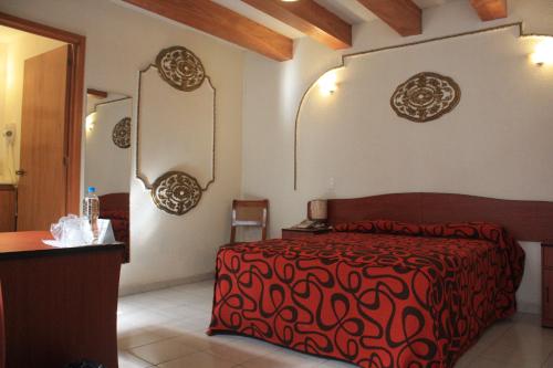 a bedroom with a bed with a red blanket and a mirror at Casa de la Luna in Mexico City