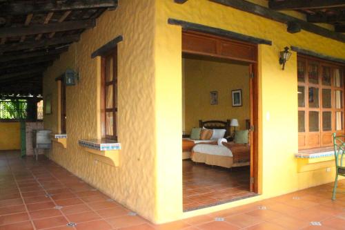 a room with a bedroom with a bed and a door at La Posada de Suchitlan in Suchitoto
