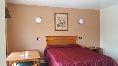 a bedroom with a bed and two plates on the wall at Deluxe Motel, Los Angeles Area in Downey