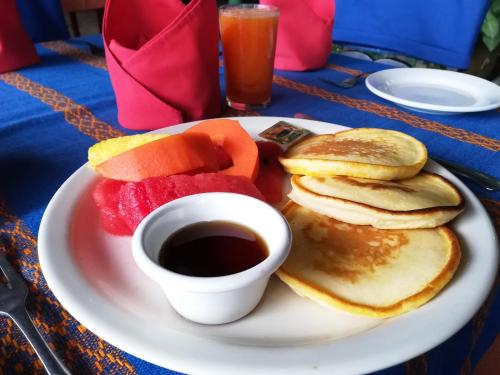 a plate with pancakes and fruit and a cup of coffee at La Posada de Suchitlan in Suchitoto
