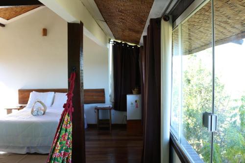 a bedroom with a bed and a sliding glass door at Chale Vista Encantada in Lavras Novas