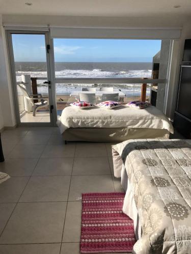 two beds in a room with a view of the ocean at Terraza Marina in Ostende
